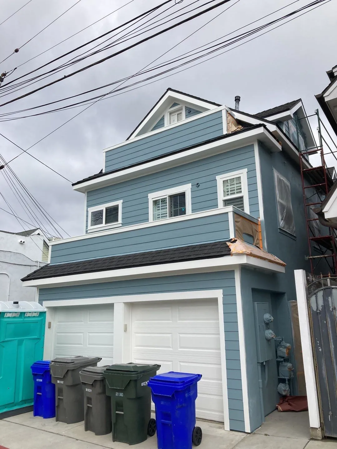 Tall, narrow Coronado home after exterior painting in blue-gray and white