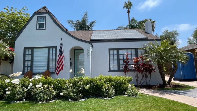 White storybook cottage with dark trim after exterior painting