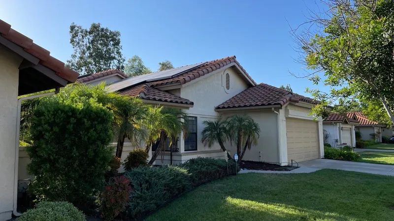Stucco home with a red tile roof after exterior painting